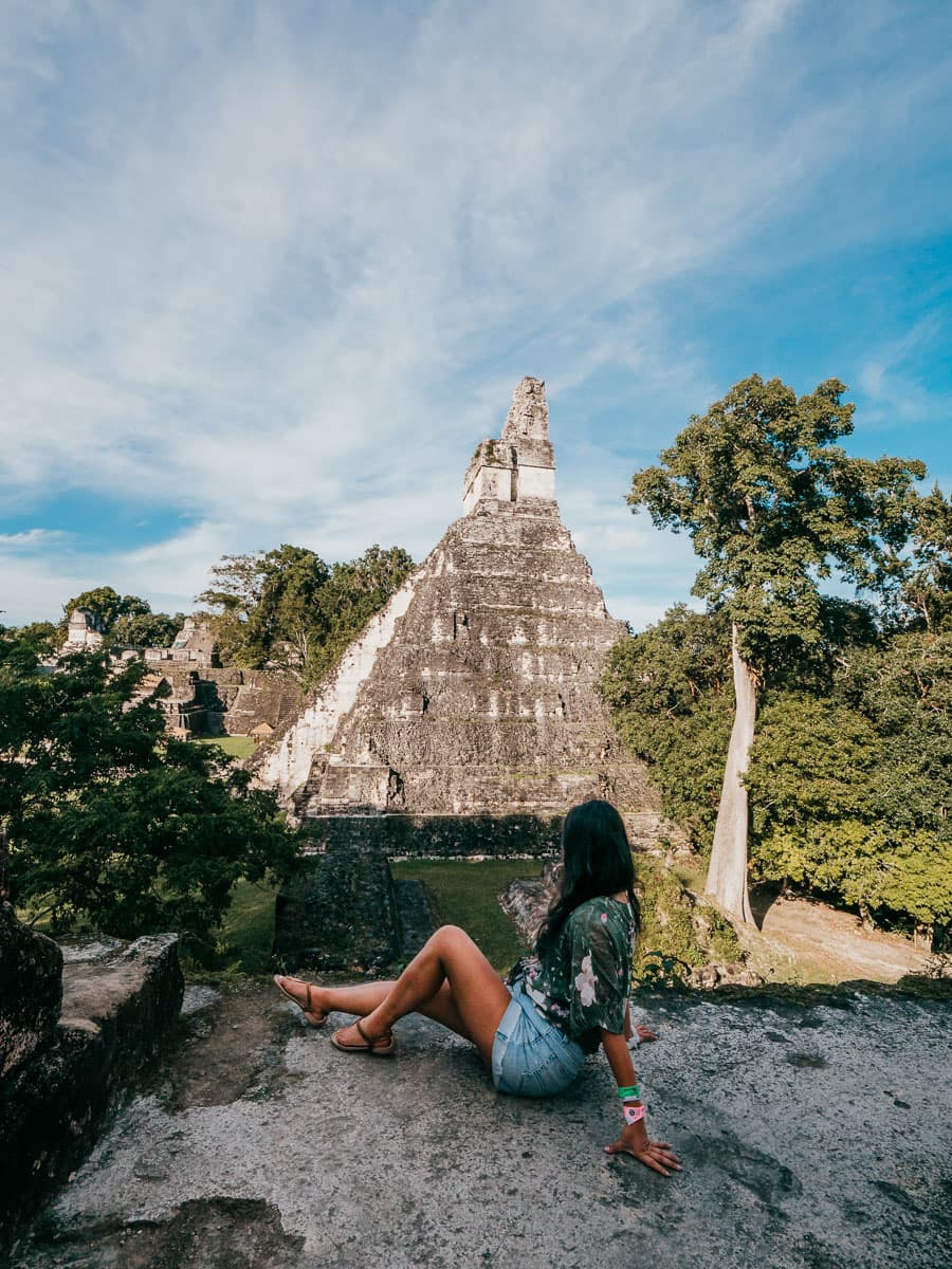 Sitting in front of the main temple in Tikal, One of the best things to do in your Flores Guatemala itinerary