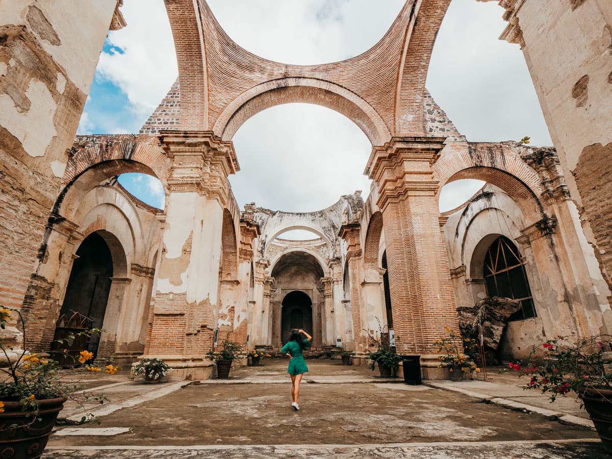 Woman standing in the collapsed ruins of a church in Antigua Guatemala itinerary