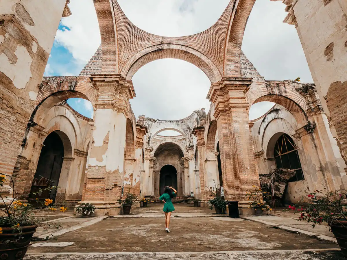 Woman standing in the collapsed ruins of a church in Antigua Guatemala itinerary