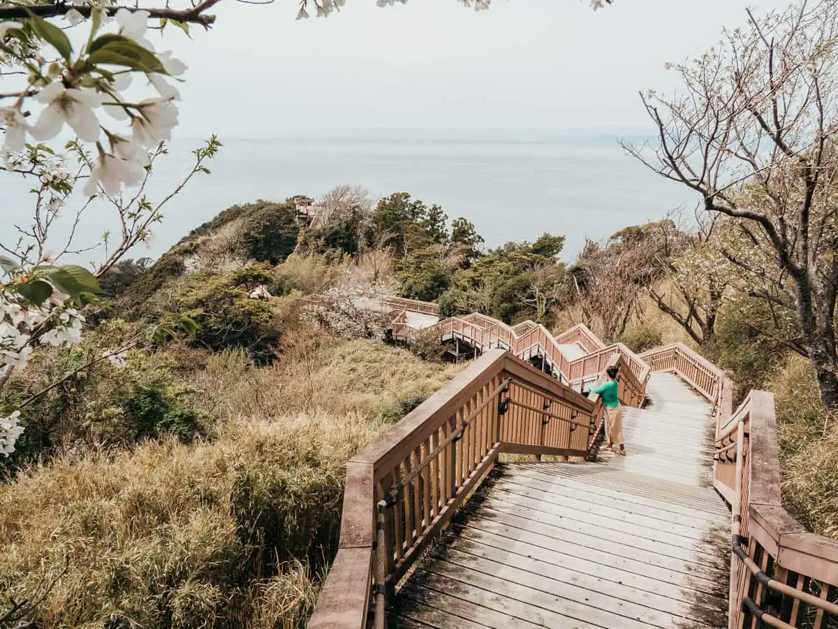 wooden staircase leading down the hill with view of ocean in izu peninsula