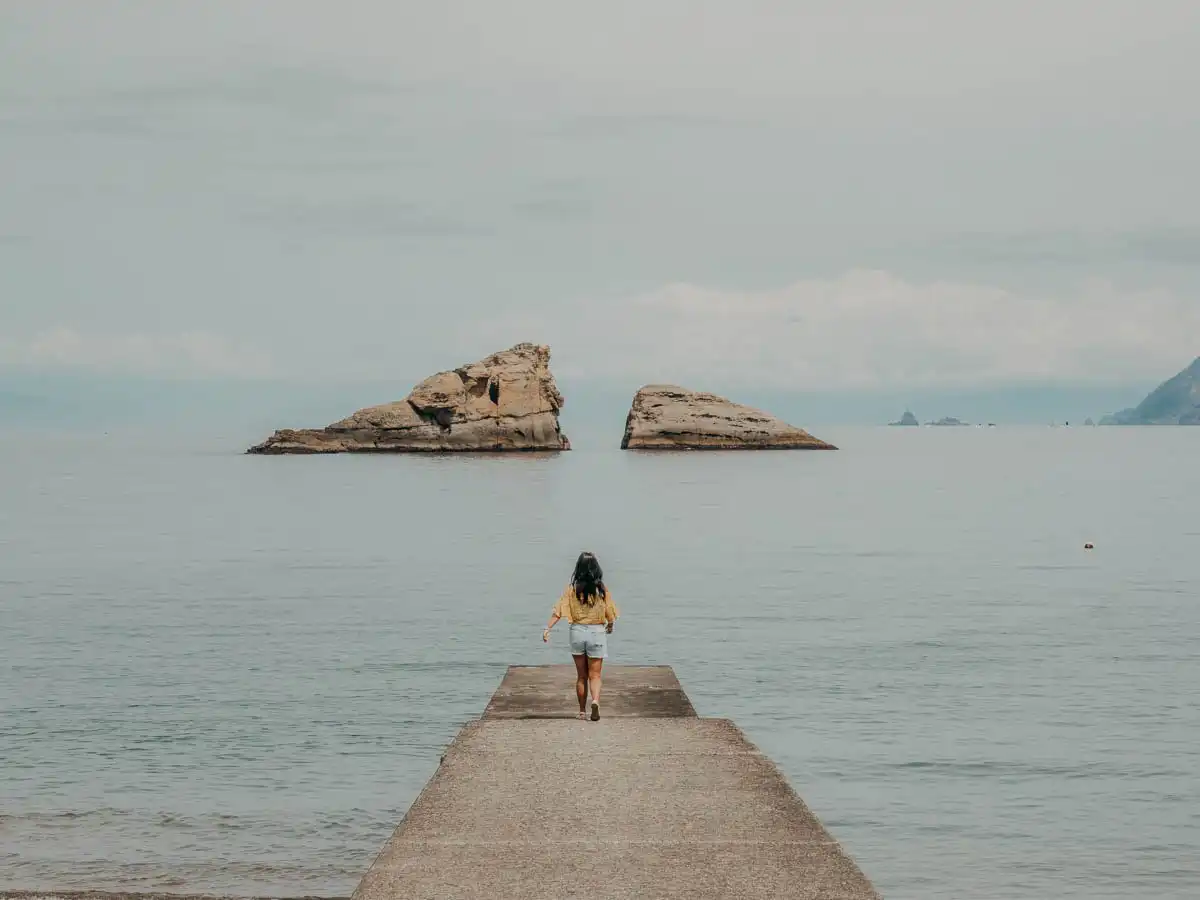 woman walking to the end of the dock which aligns with mount fuji
