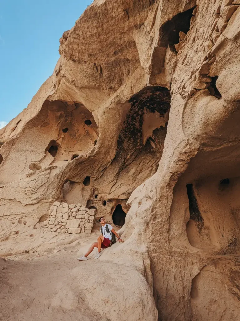 Man posing around cave dwellings