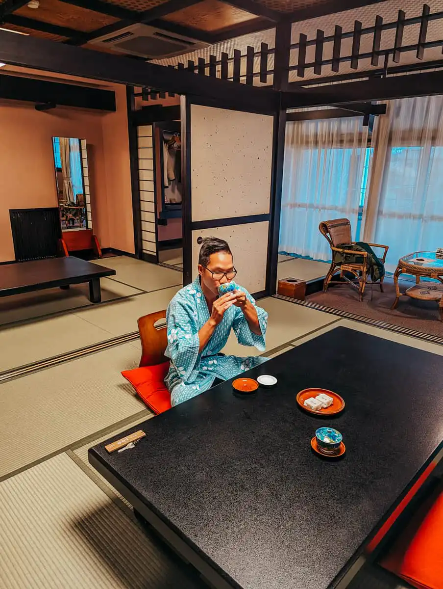 man drinking tea inside of ryokan