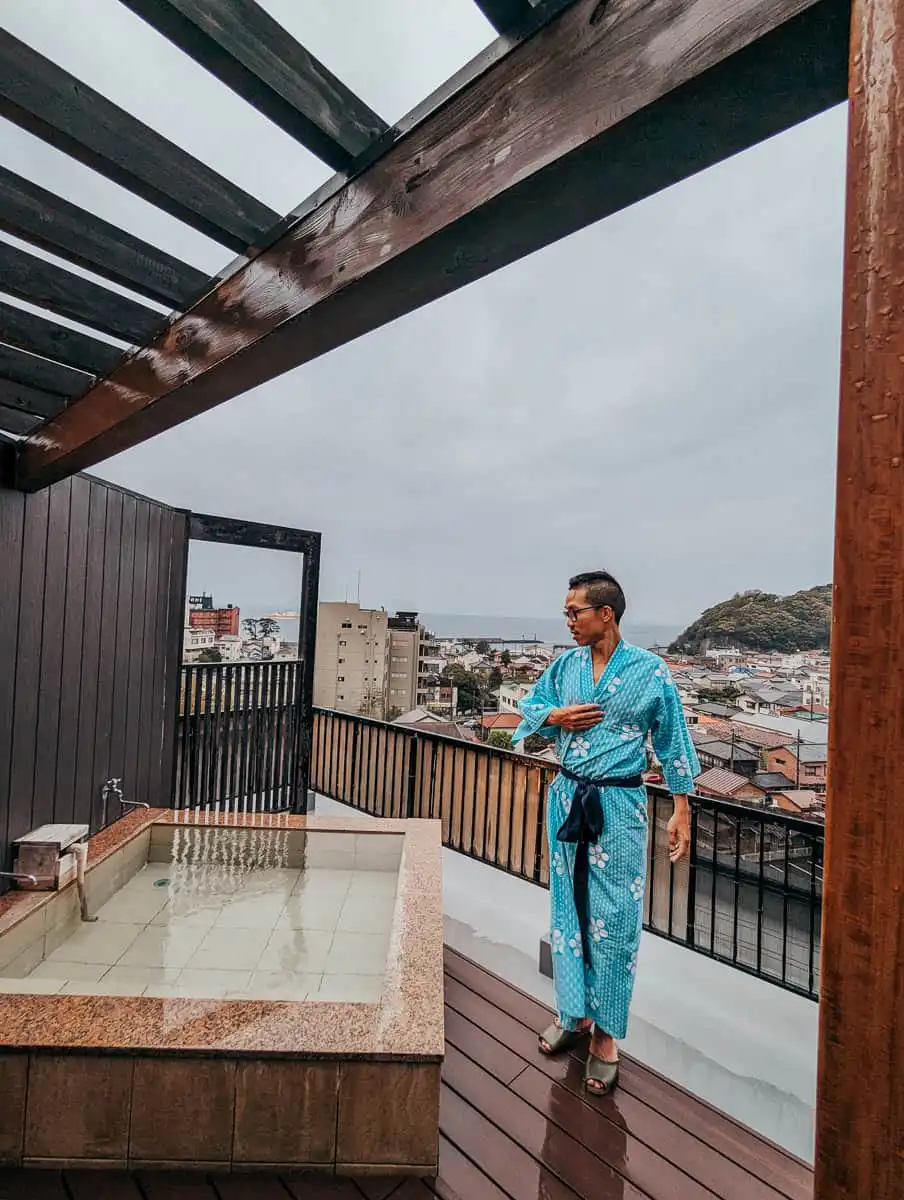 Man standing on the rooftop terrace onsen in Japan
