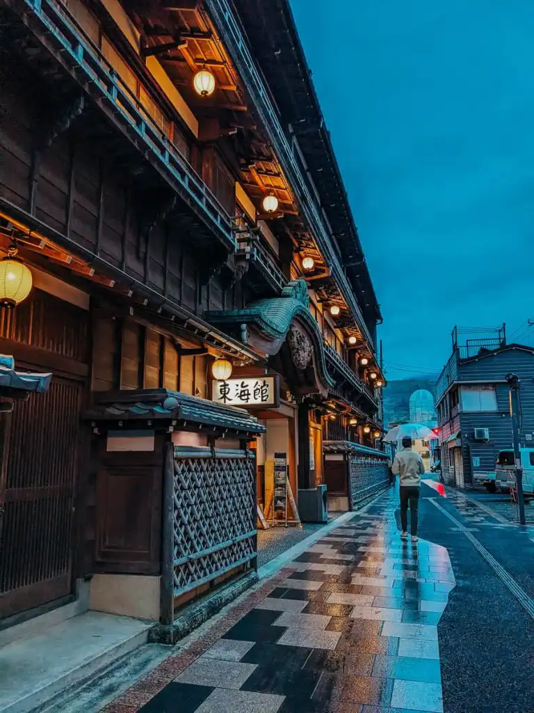 Town of ito at night man with umbrella