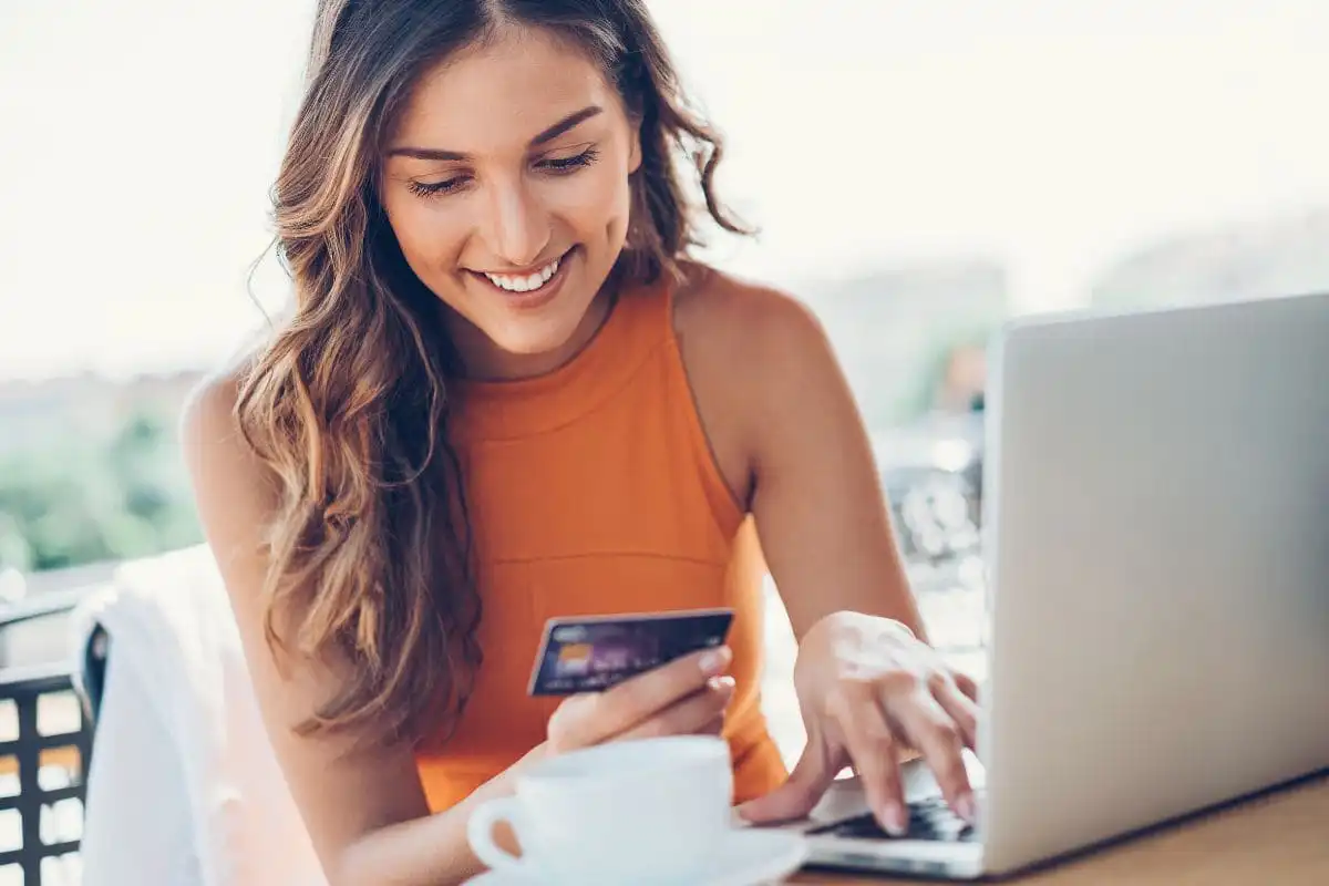 woman using card to purchase something on laptop