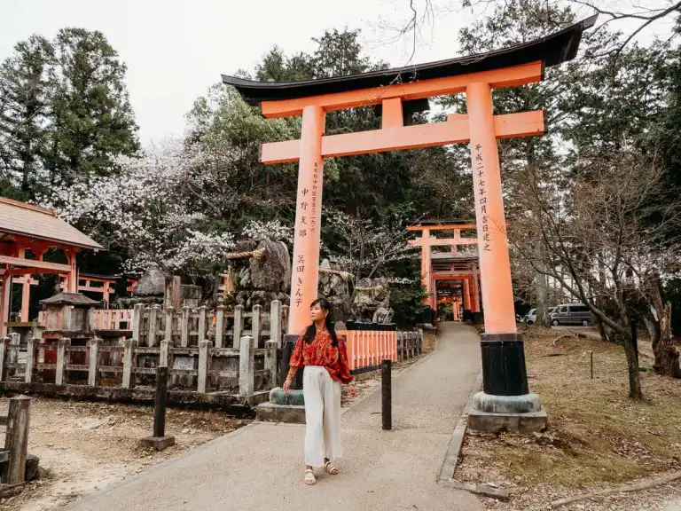 Woman standing in front of tori gates at Fushimi Inarii during our 2 days Kyoto itinerary