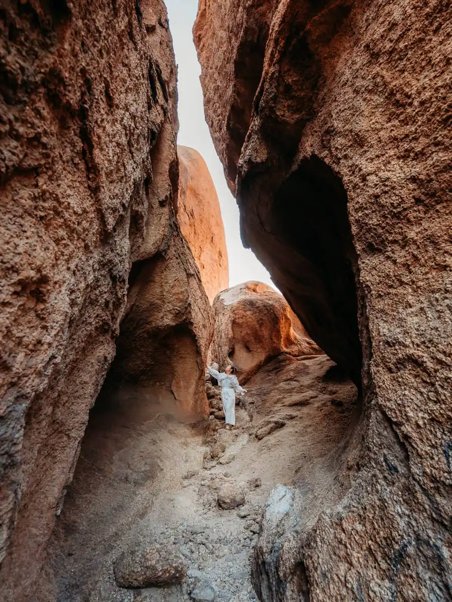woman standing among the crevice rock of spitzkoppe