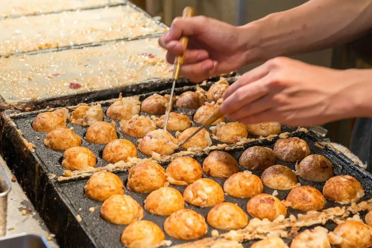 person making takoyakis in Osaka