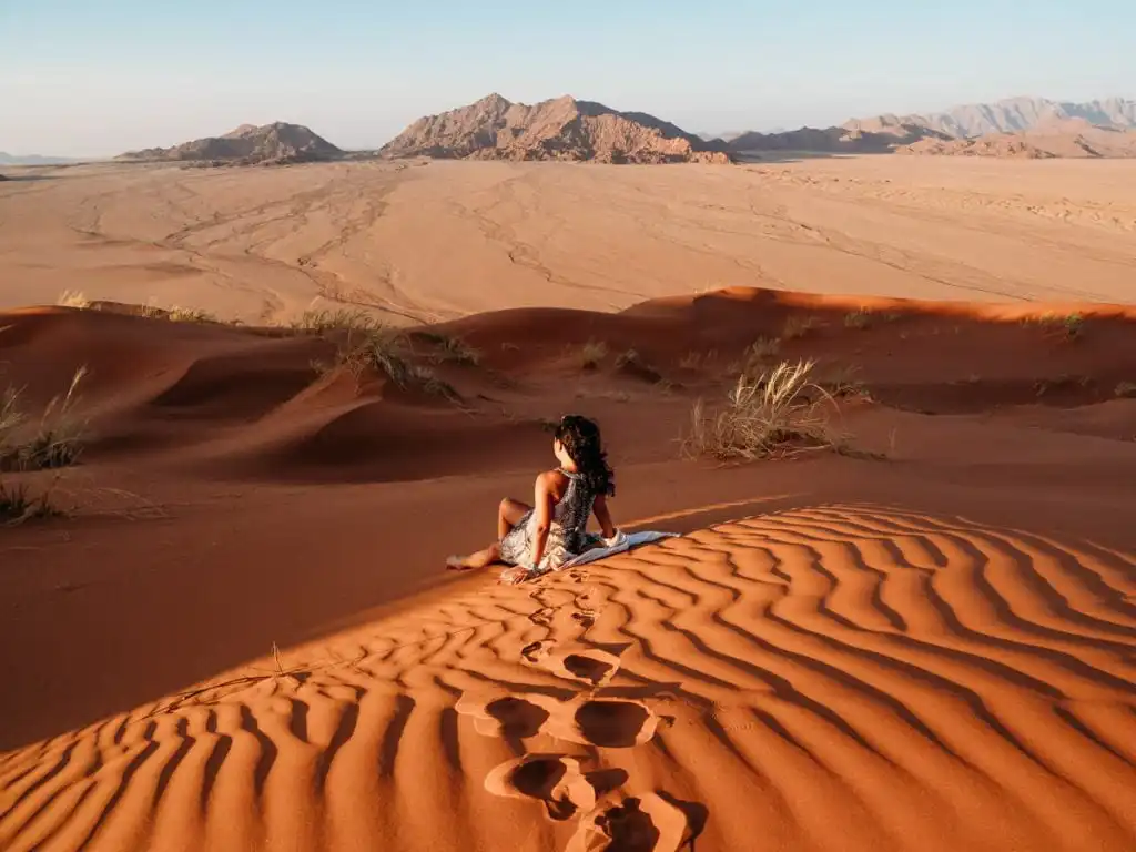 Sitting on the sands of elim dunes at sunset