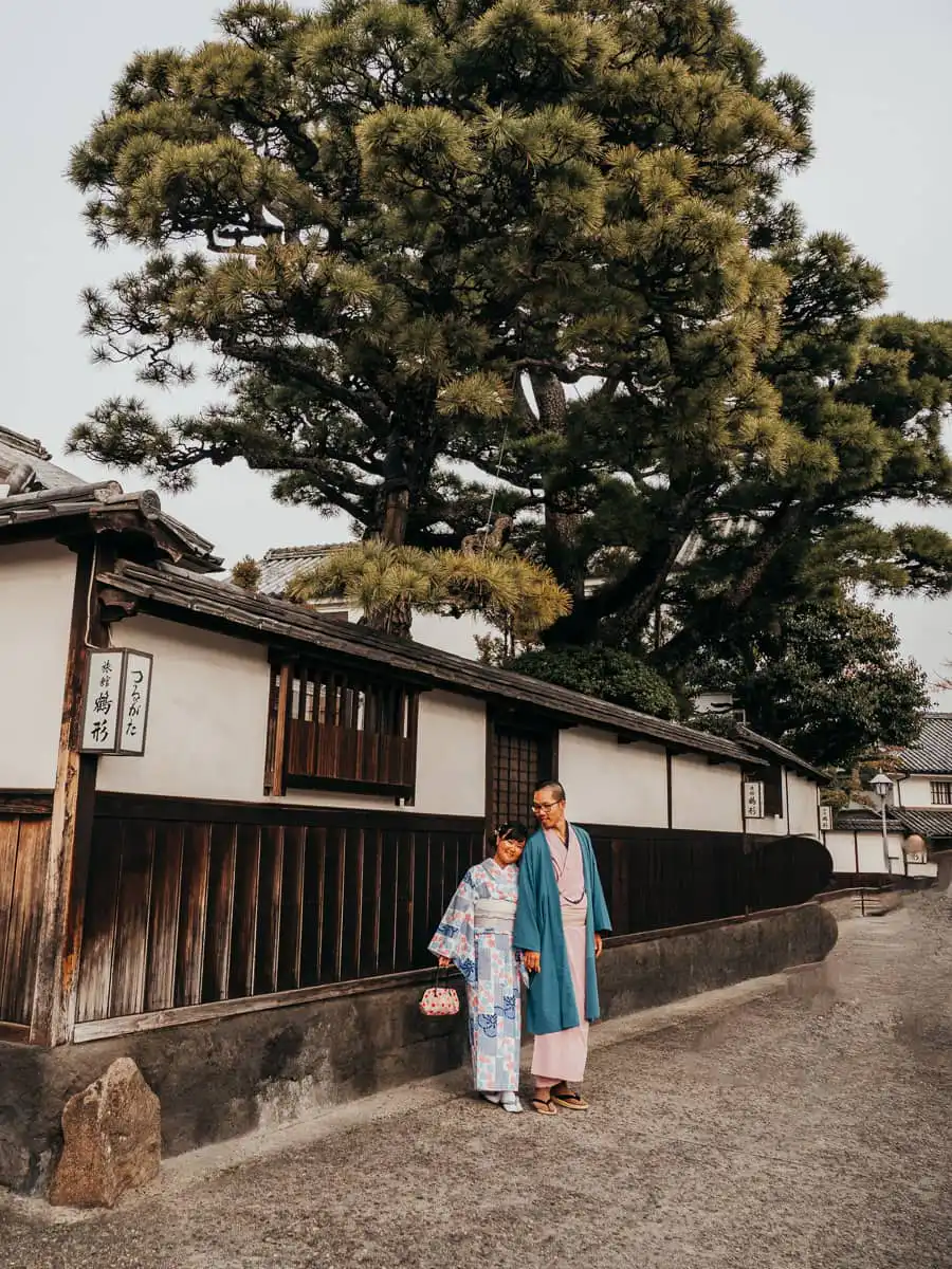 man and womand standing in front of wall in japan