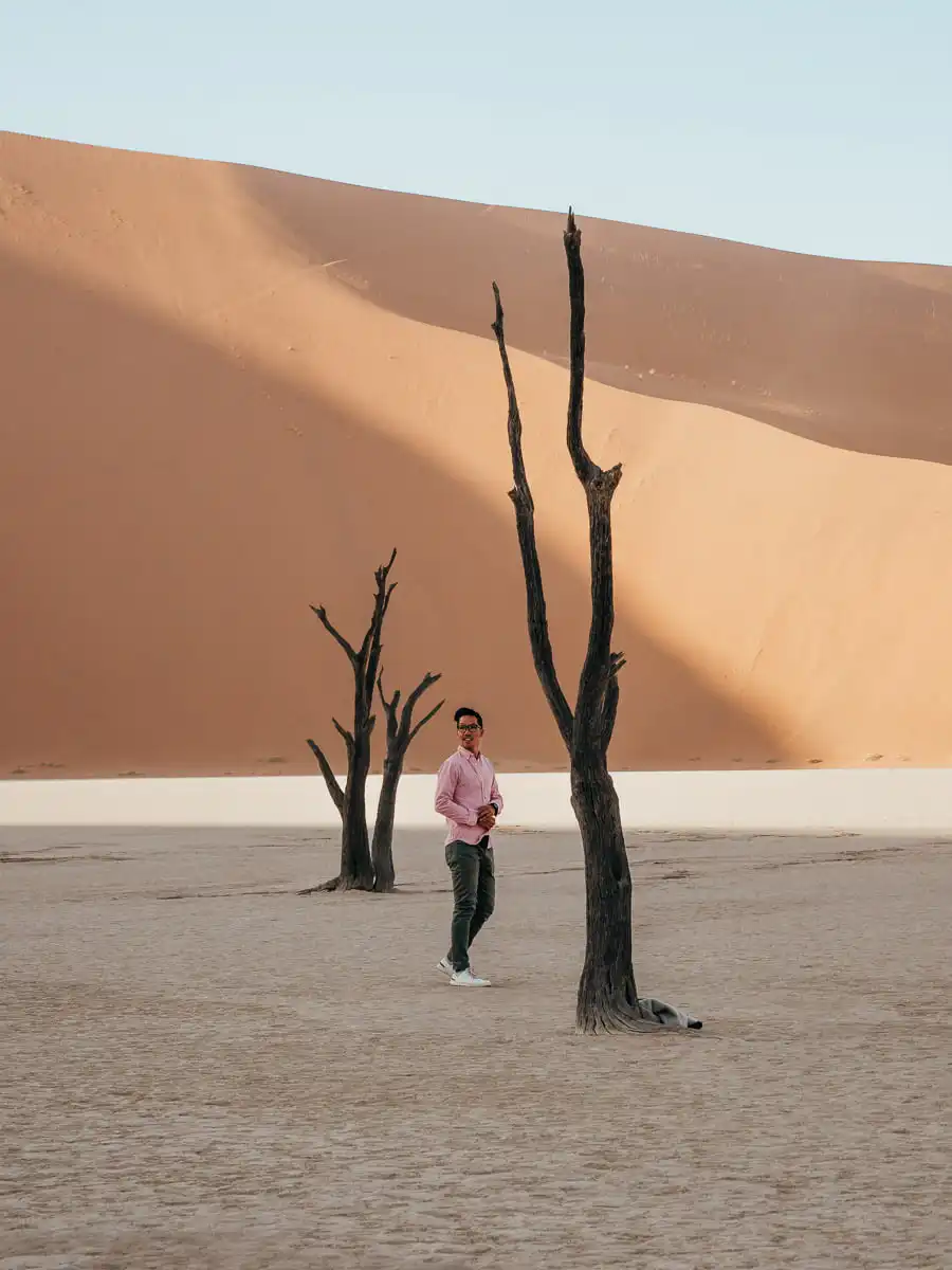 man standing next to tree in Deadvlei