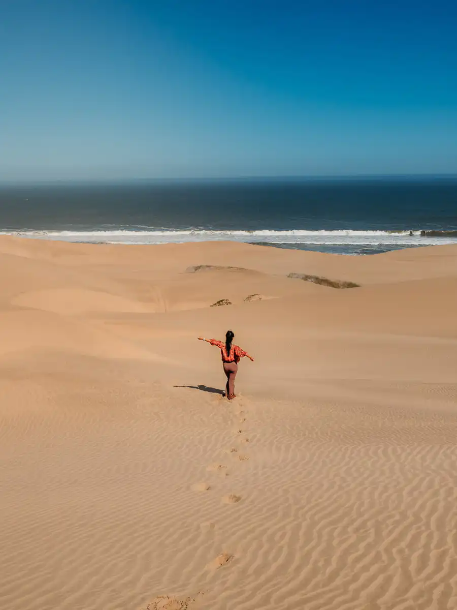 Standing along the dunes in front of the ocean at Sandwich Harbour