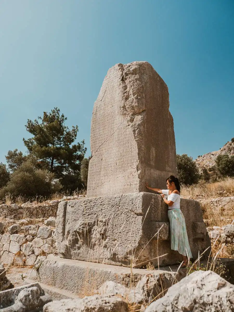 Woman touching the stone in Patara ruins