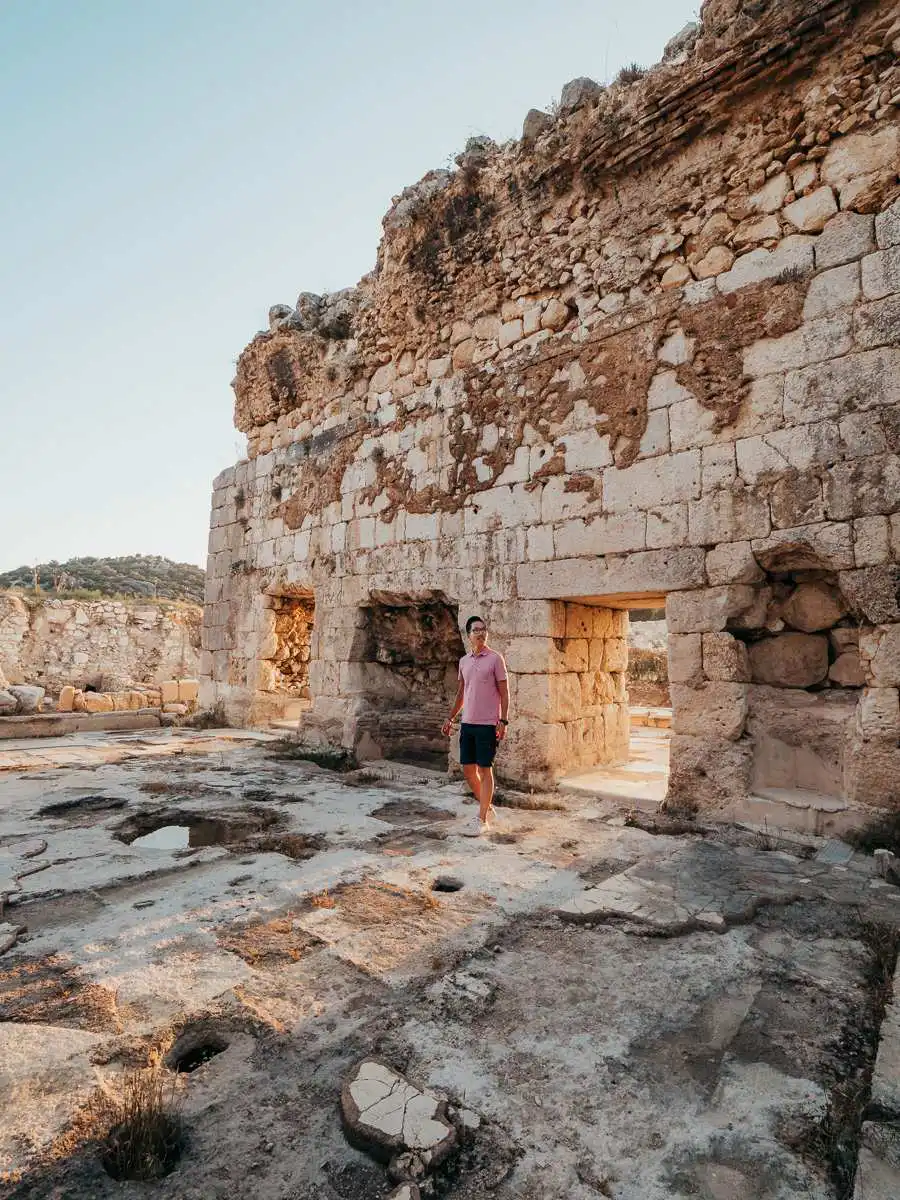 Man walking at Patara ruins at sunset