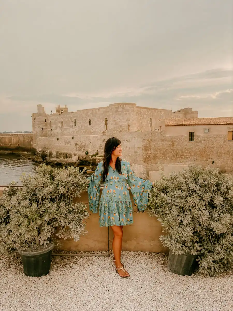 standing in front of castle in Syracuse