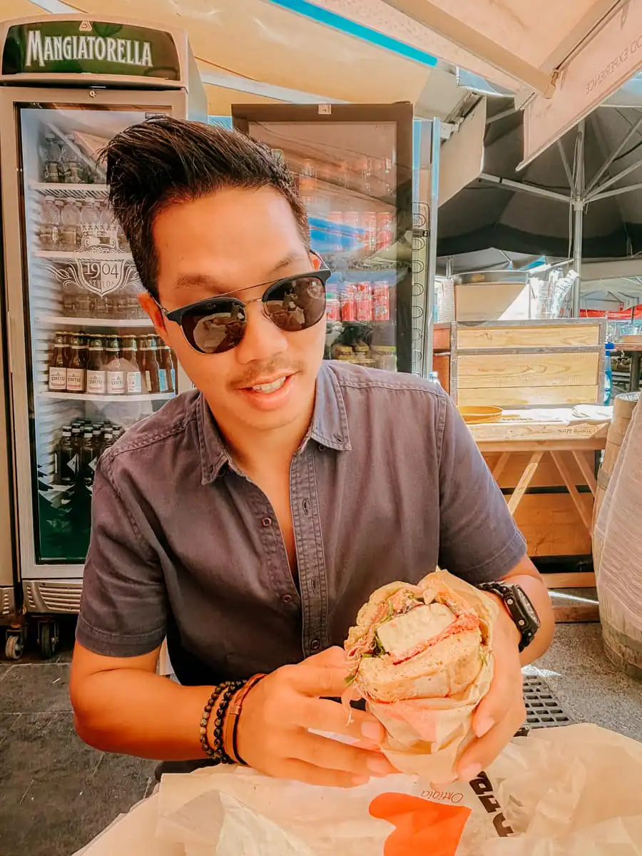 Ryan eating the sandwich in Ortigia market