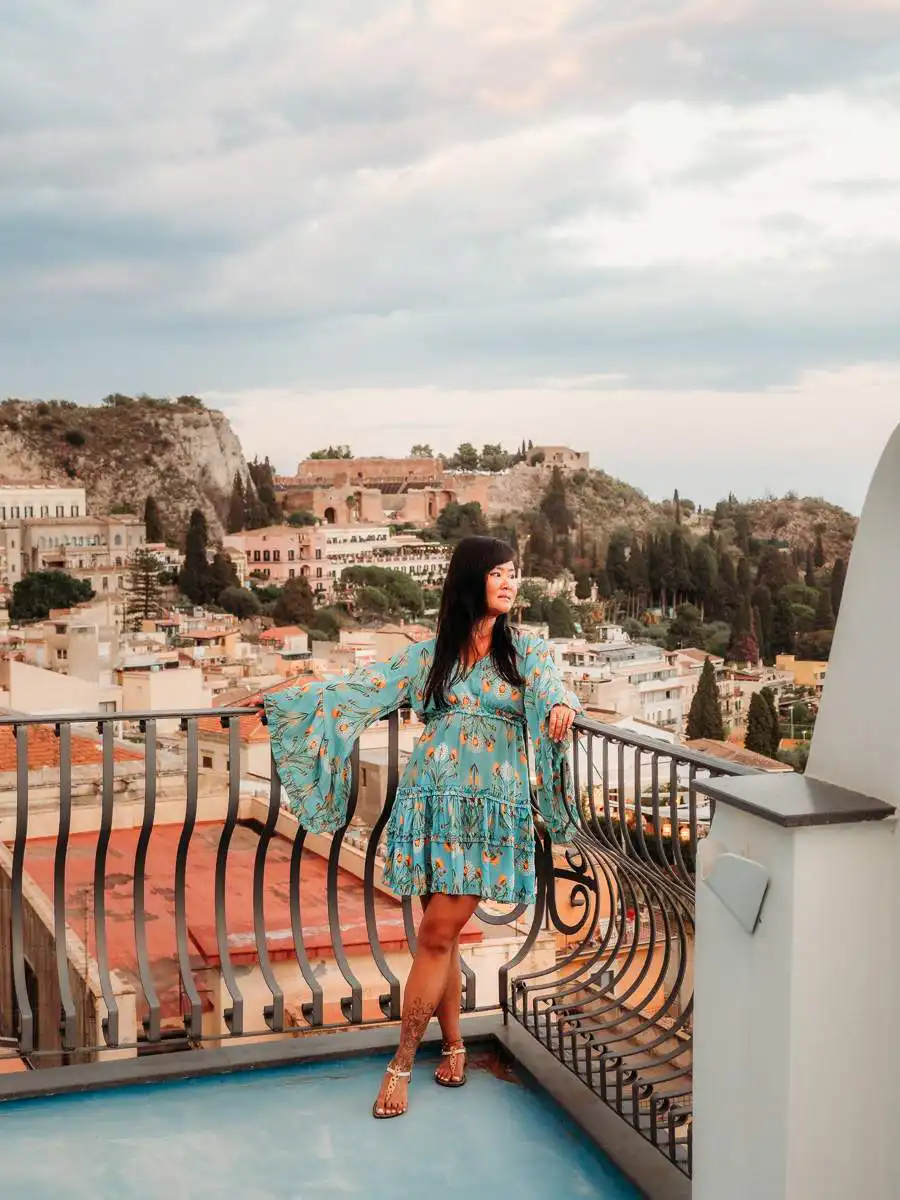 Woman standing on rooftop balcony in Taormina, one of the best things to do in Taormina