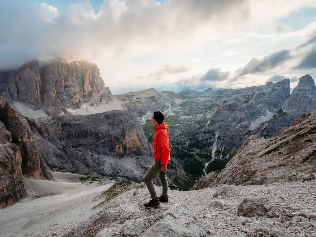 Standing at the top of Tre Cime at sunset on via ferrata trail
