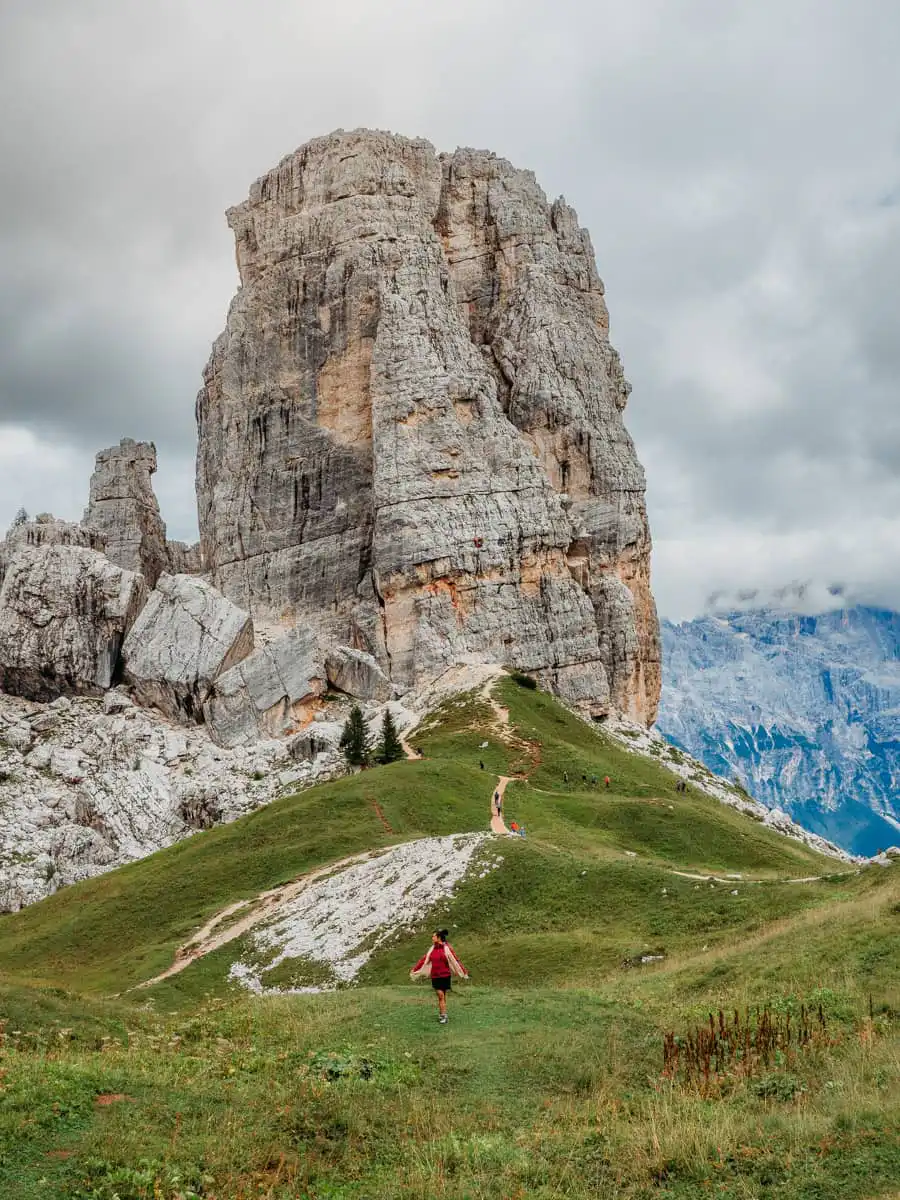 Cinque torri main tower, woman standing in the field, one of the best things to do in the Dolomites