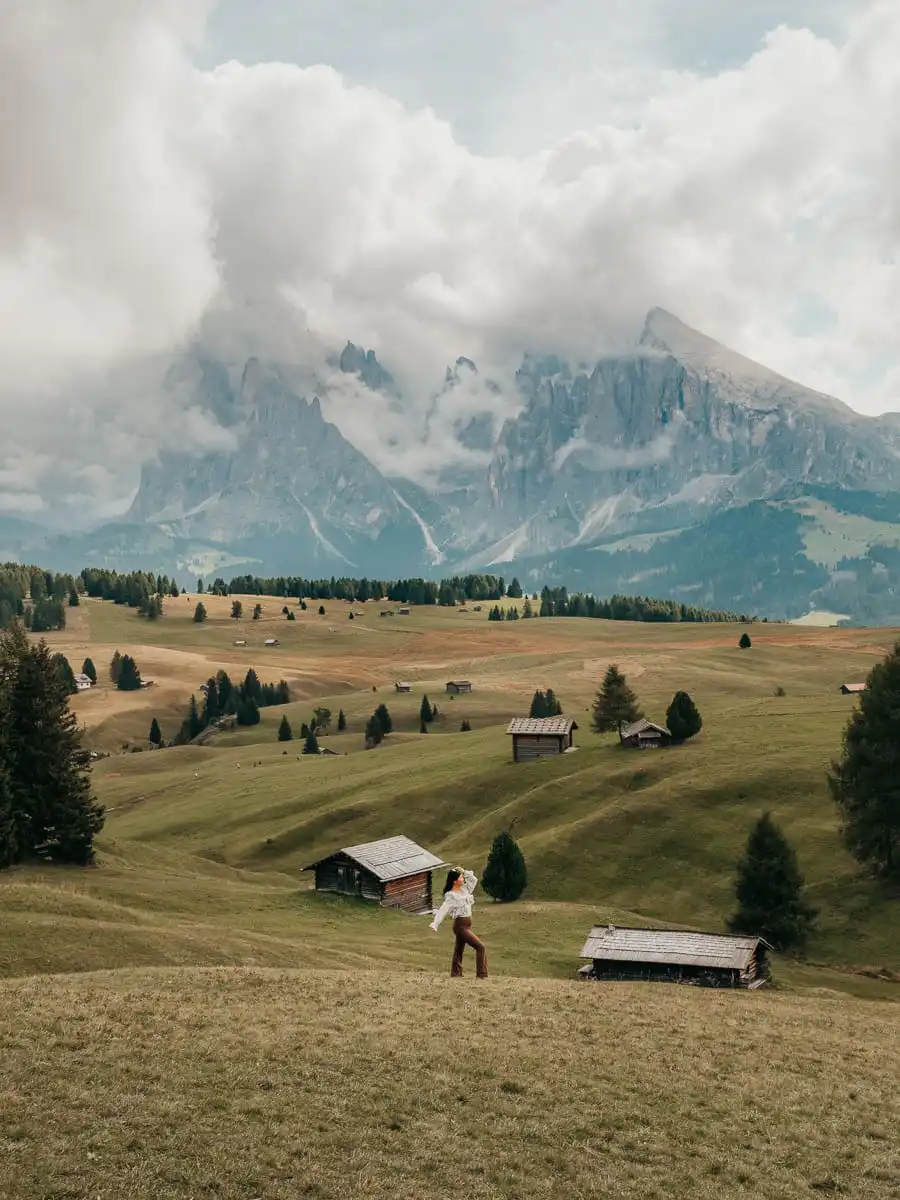 Woman standing around the mountain huts in Alpe di Siusi