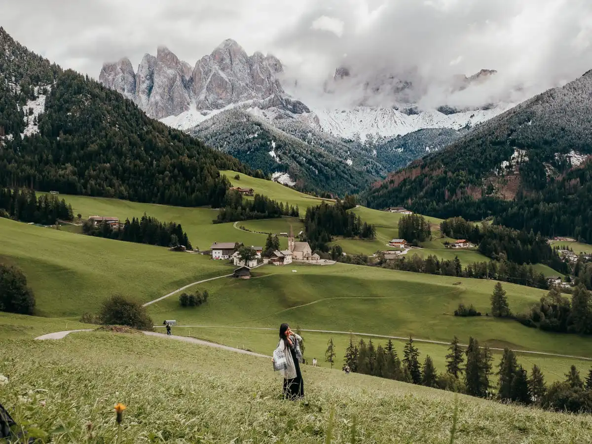 Val di funes church with woman standing in front of viewpoint