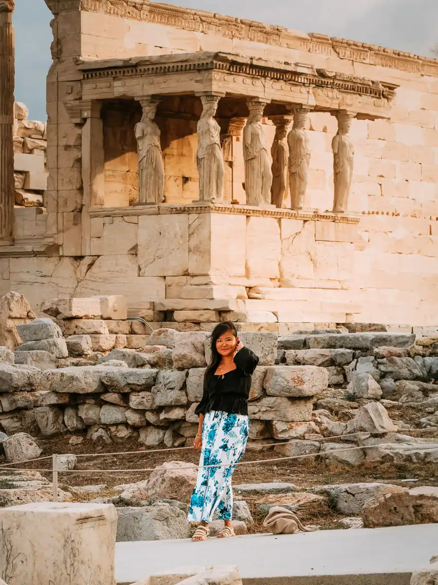 Woman standing in front of statues at acropolis