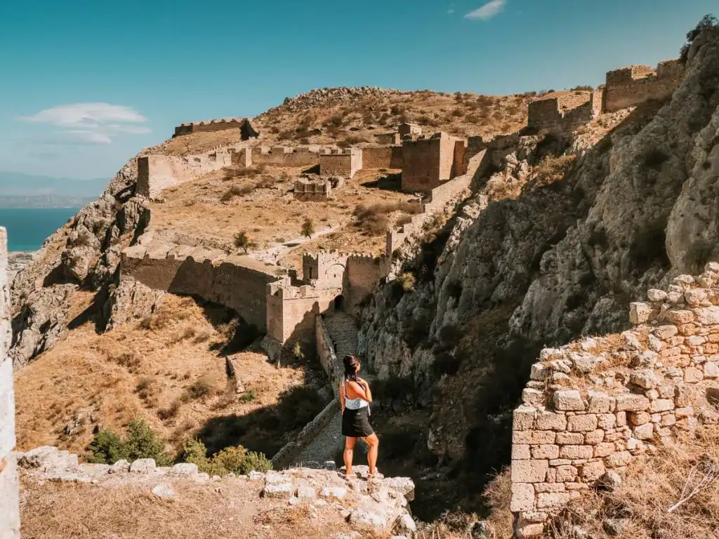 Woman standing in front of Acrocorinth fortress in Corinth Greece