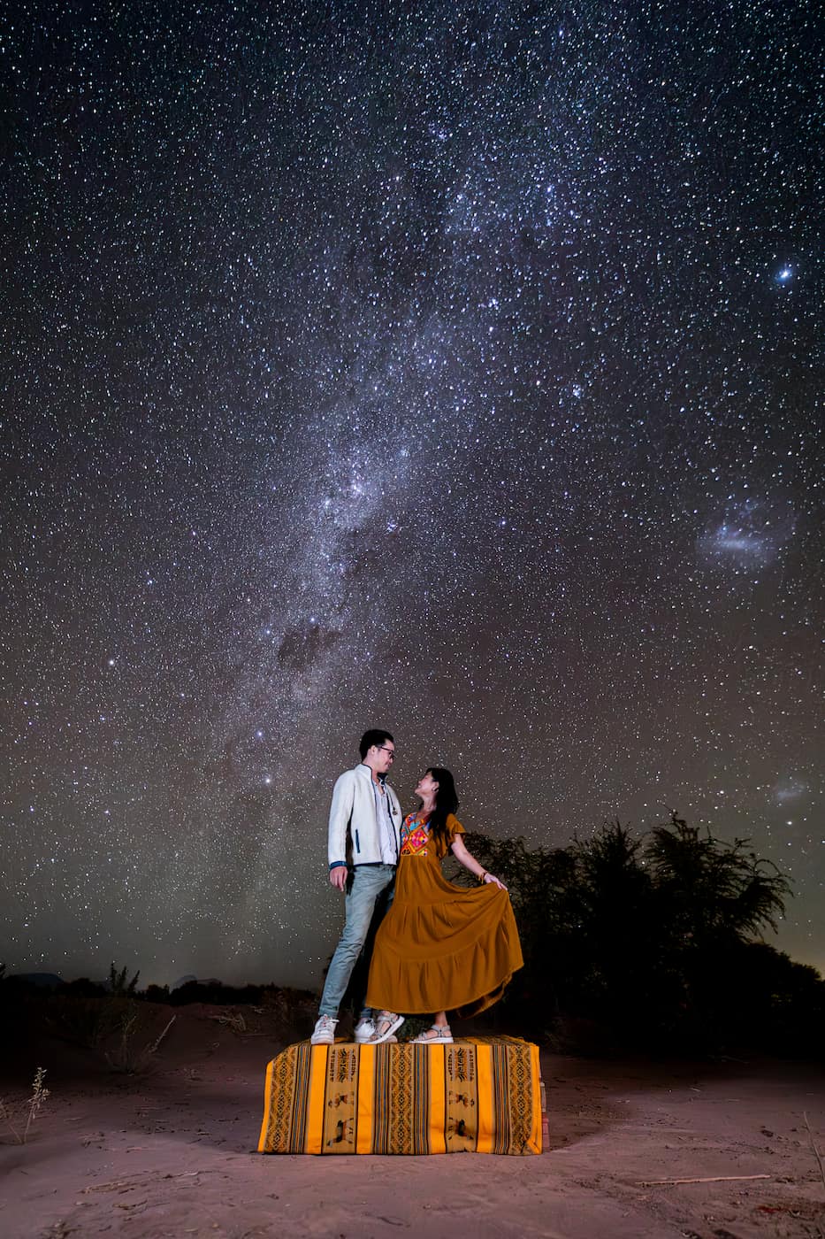 Starphotography portrait of woman and man, with backdrop of the milky way, in the atacama desert