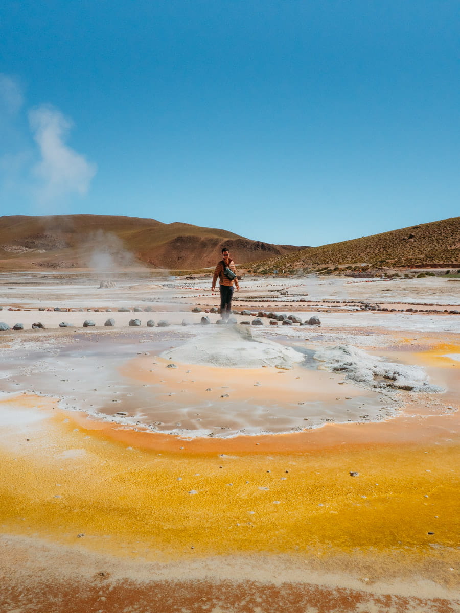 Standing in front of yellow colour geyser in El Tatio
