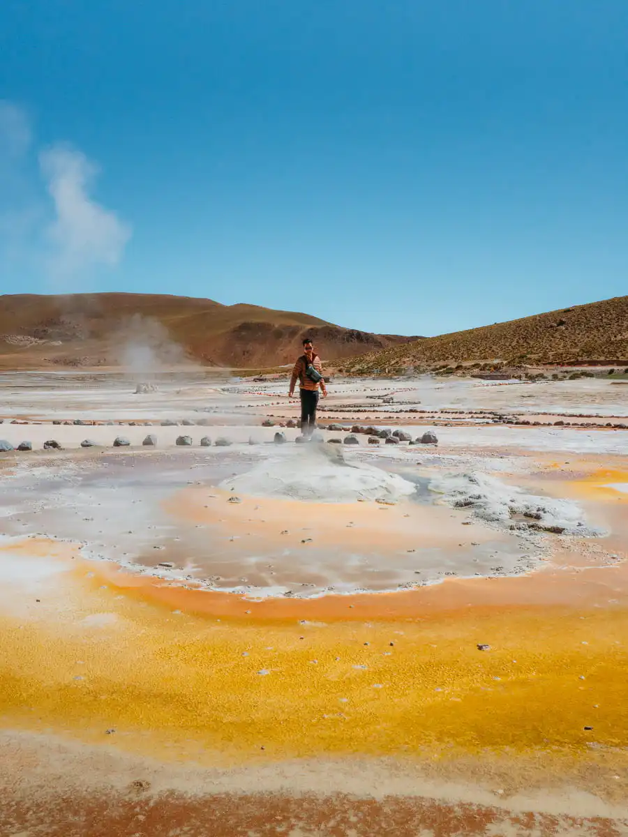 Standing in front of yellow colour geyser in El Tatio