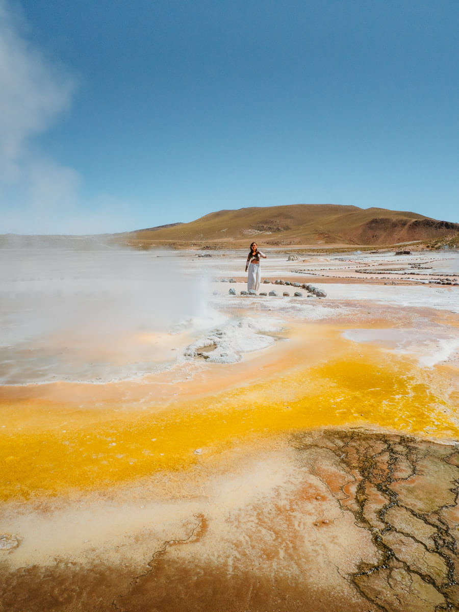 Standing in front of yellow pool in el tatio geyser