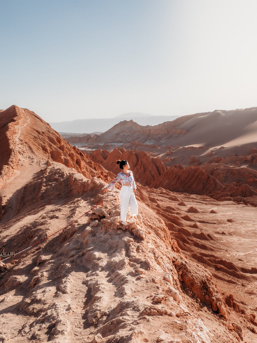 Standing at sand dunes of valle de la luna, woman standing there, one of our favourite things to do in San Pedro de Atacama