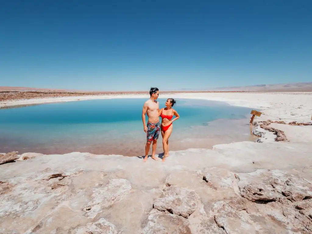Woman and man standing in front of laguna baltinache, one of our favourite things to do in San pedro de atacama