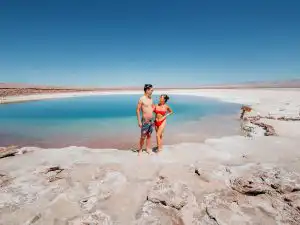 Woman and man standing in front of laguna baltinache, one of our favourite things to do in San pedro de atacama