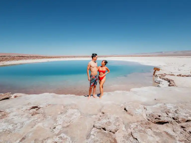 Woman and man standing in front of laguna baltinache, one of our favourite things to do in San pedro de atacama
