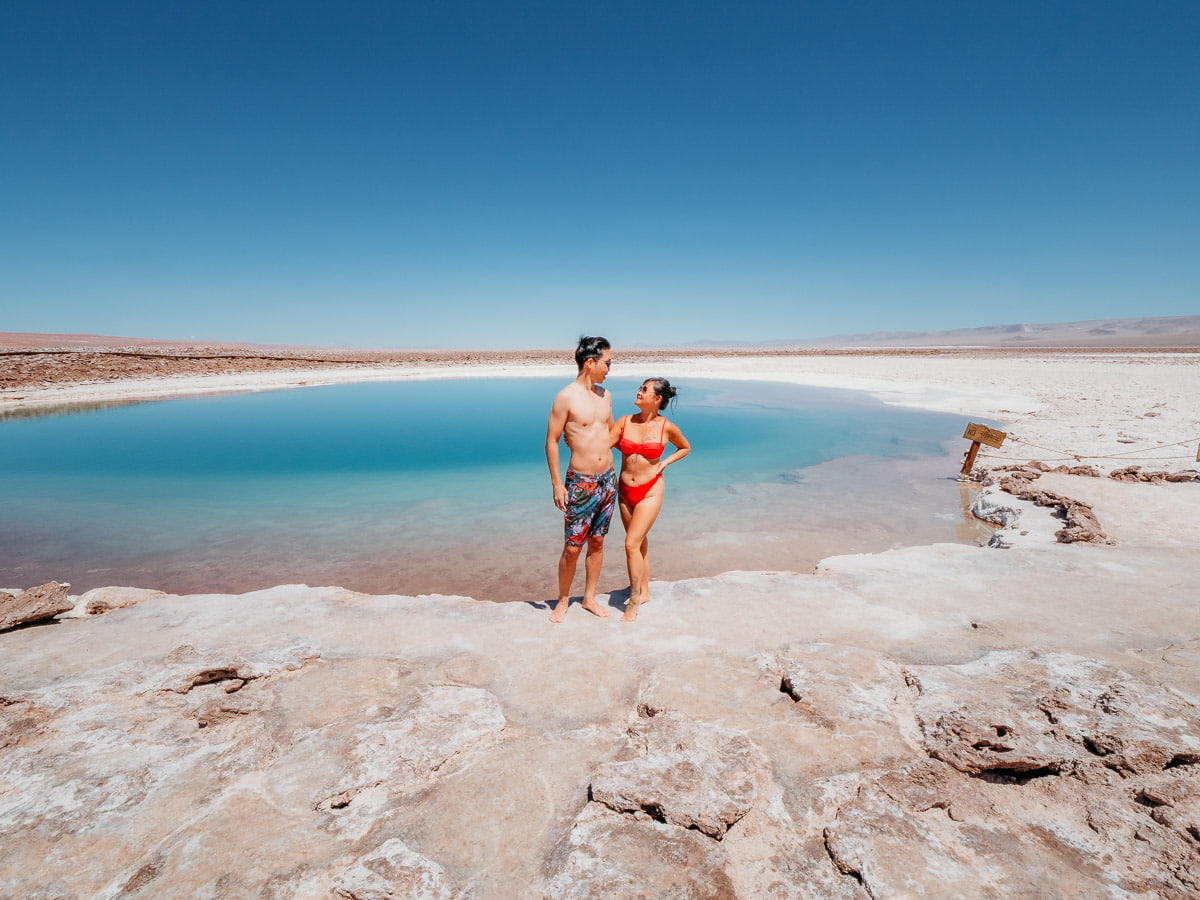 Woman and man standing in front of laguna baltinache, one of our favourite things to do in San pedro de atacama