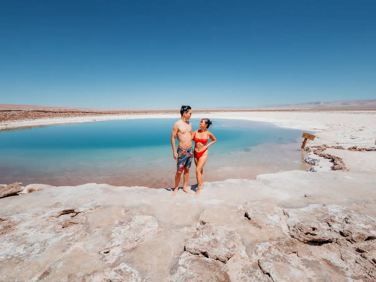 Woman and man standing in front of laguna baltinache, one of our favourite things to do in San pedro de atacama