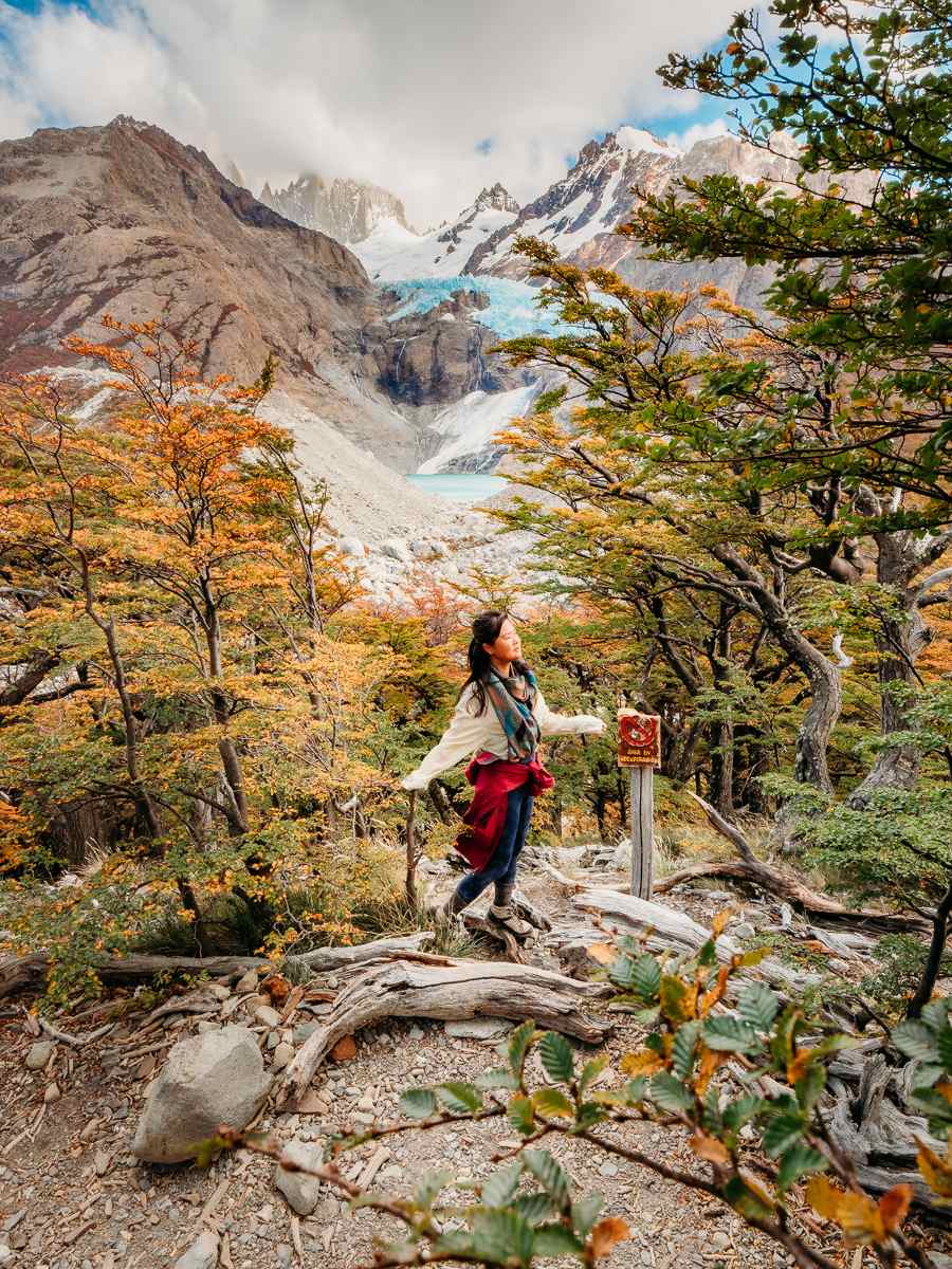 Woman standing amongst the forest in front of the mountains with glacier