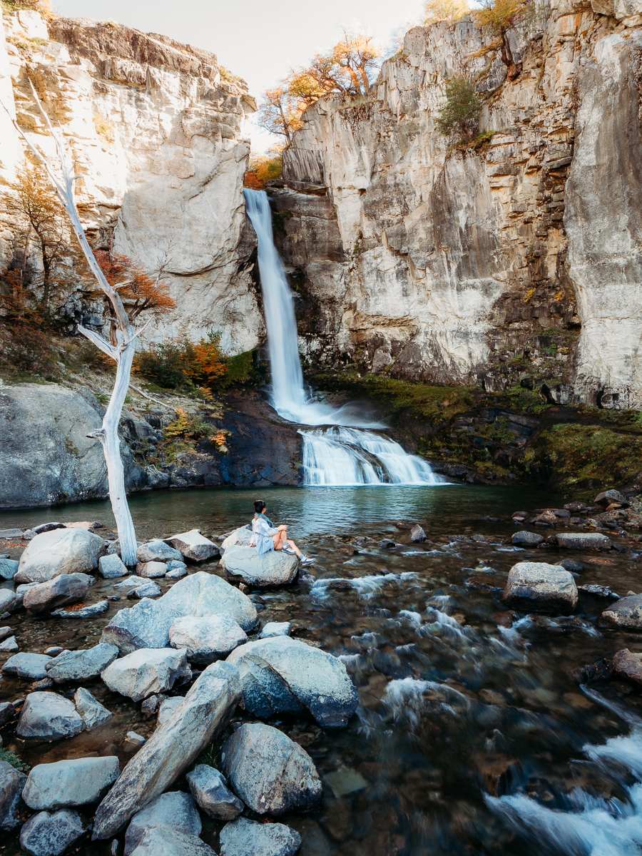 woman sitting next to the waterfall in Chorillo del Salto