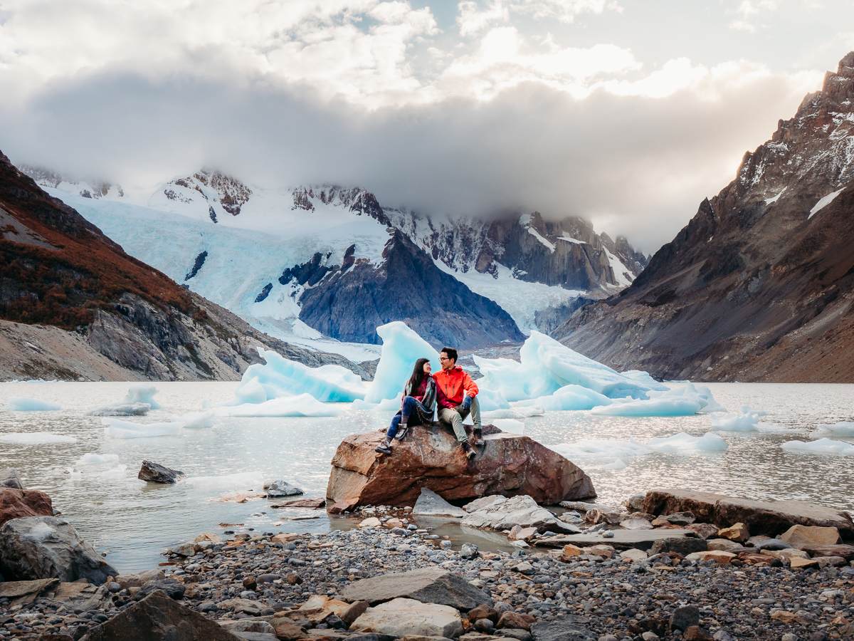 Couple sitting in front of Icebergs in Argentina Patagonia