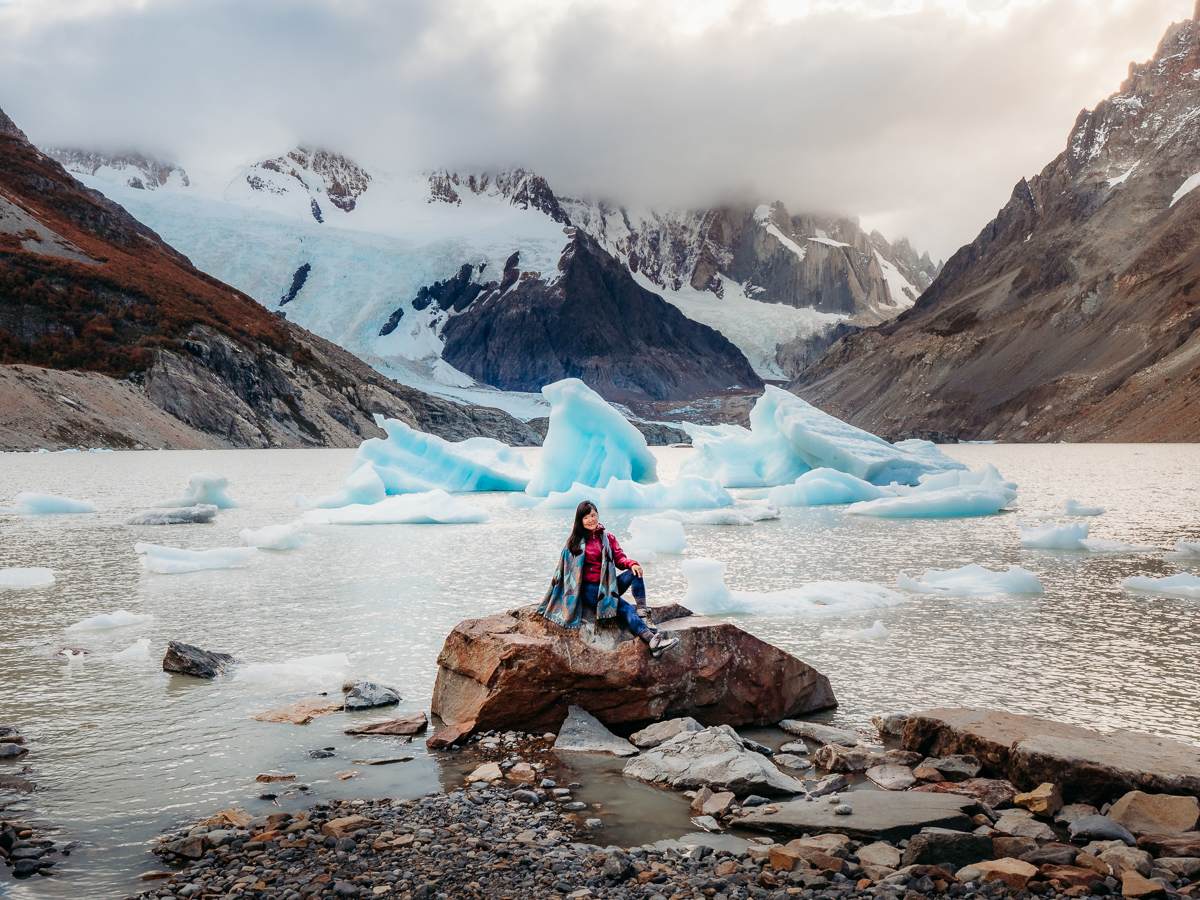 sitting on rock in front of glaciers in Argentina Patagonia
