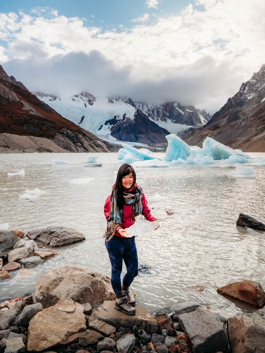 woman holding up piece of iceberg in Argentina Patagonia