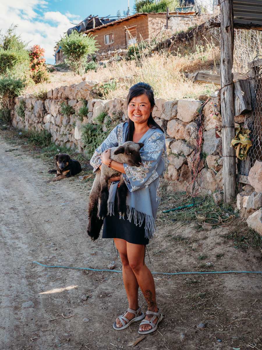 holding a goat at la granja del colca