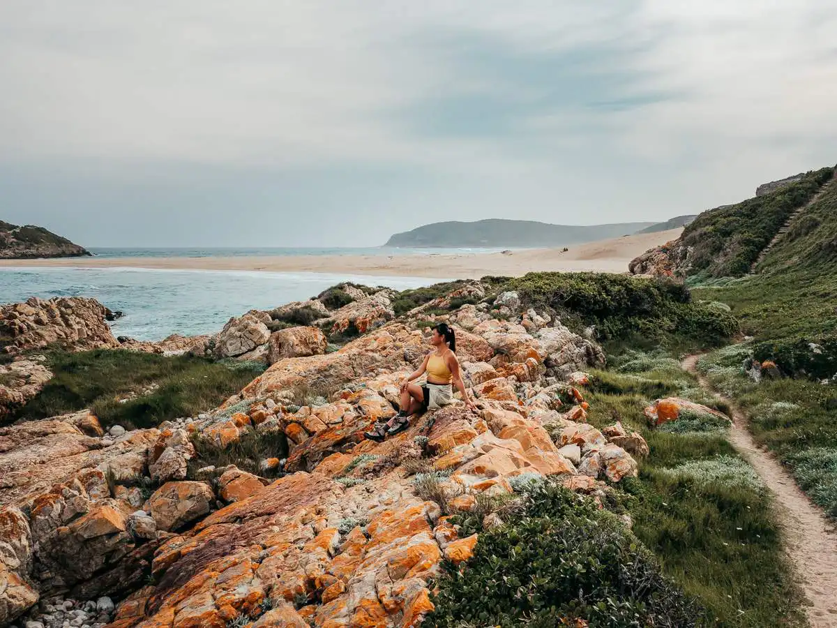 sitting on the rocks at Robberg Nature Reserve on our Garden Route Itinerary
