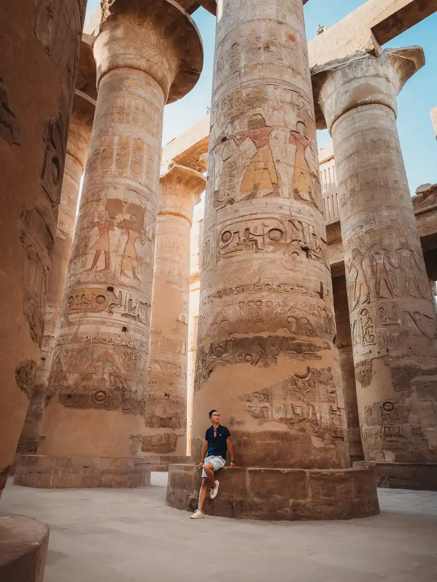 Man sitting next to pillar in Luxor temple