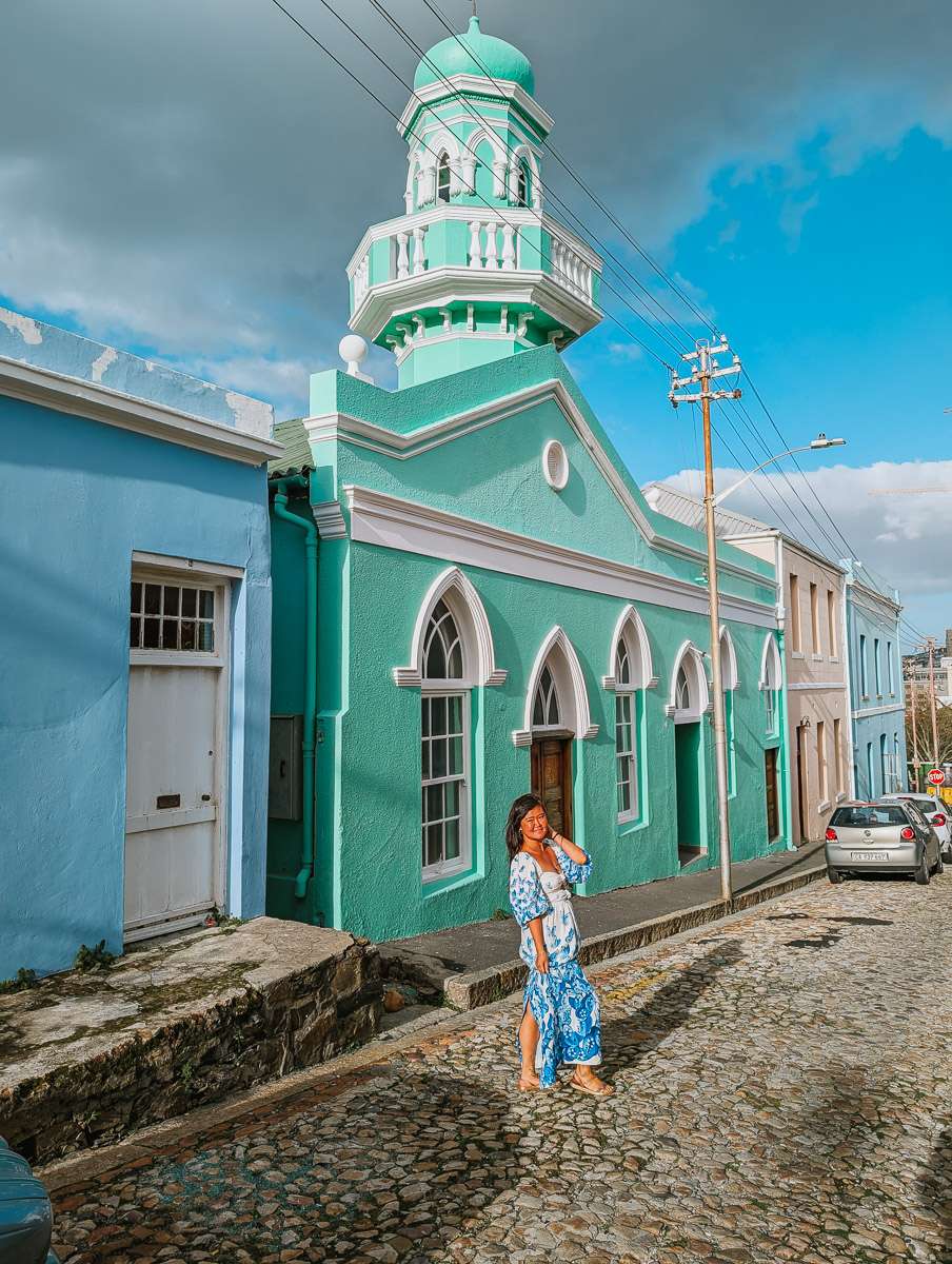 Woman standing in front of green mosque in Cape Town