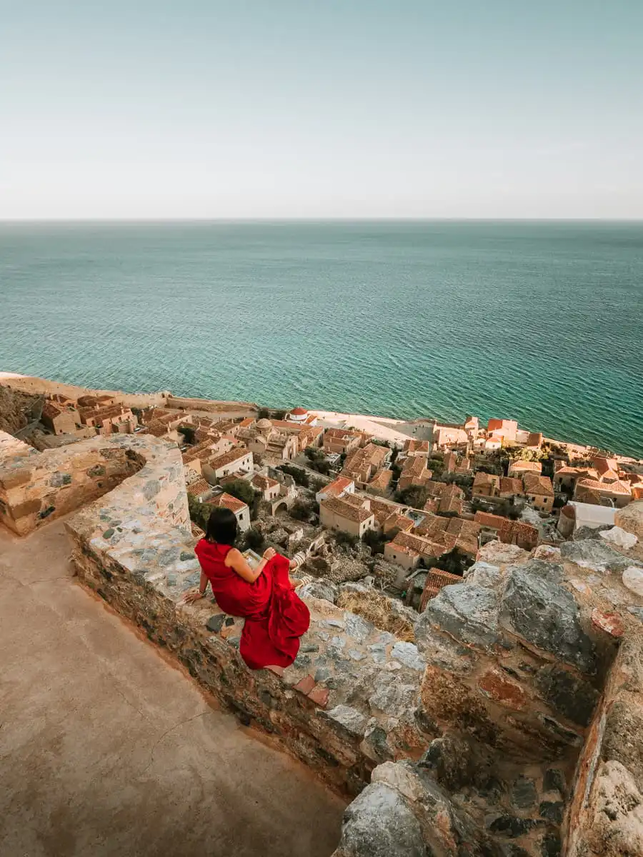 woman sitting on castle wall of monemvasia