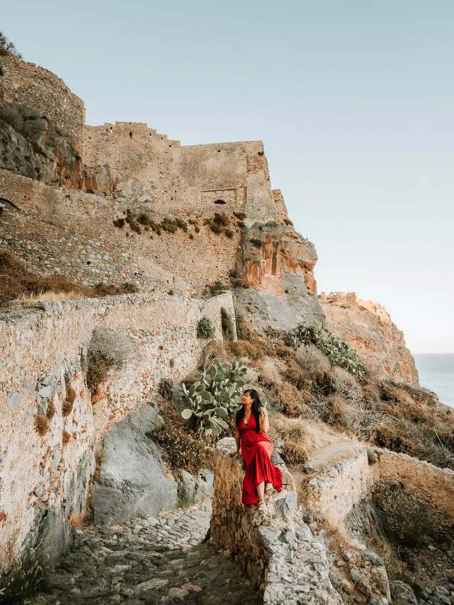 woman sitting on winding steps up to Monemvasia