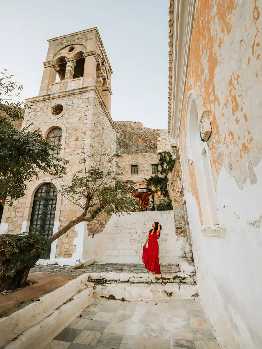 woman standing next to church in monemvasia